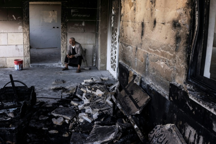 Ahmed Abou Mahmoud, 64 ans, dans une mosquée incendiée, selon les autorités palestiniennes, par des colons dans le village de Qusra, en Cisjordanie occupée, le 26 juillet 2026 ( AFP / JOHN WESSELS )