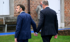 Emmanuel Macron (G) et Friedrich Merz se tiennent la main à leur arrivée au sommet informel de l'UE au château belge d'Alden Biesen en Belgique le 12 février 2026 ( AFP / NICOLAS TUCAT )