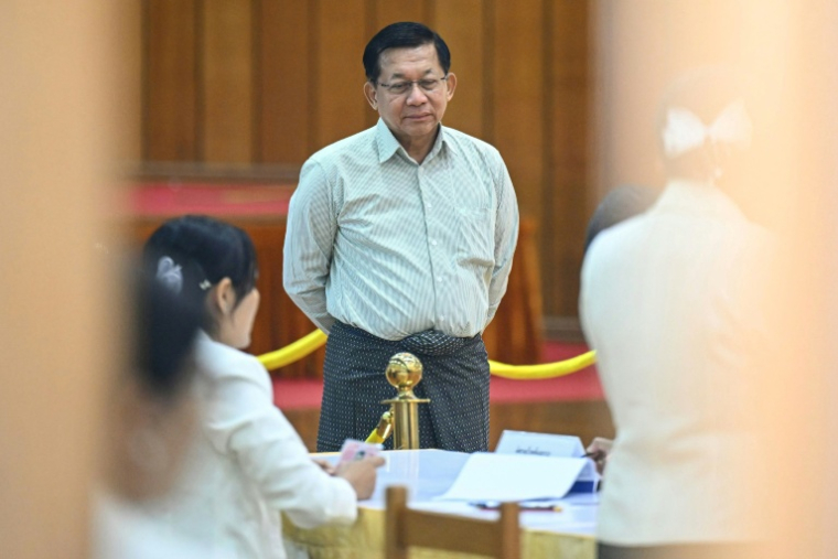 Le chef de la junte birmane Min Aung Hlaing (au centre) arrive pour voter lors de la première phase des législatives birmanes, dans un bureau de vote à Naypyidaw, le 28 décembre 2025 ( AFP / Sai Aung MAIN )