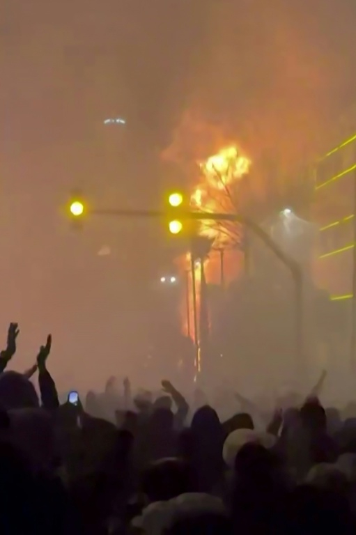 Capture d'écran vidéo faite le 14 janvier 2026 à partir d'images UGC publiées sur les réseaux sociaux le 9 janvier 2026 montrant des manifestants devant un bâtiment en feu à Téhéran ( UGC / - )