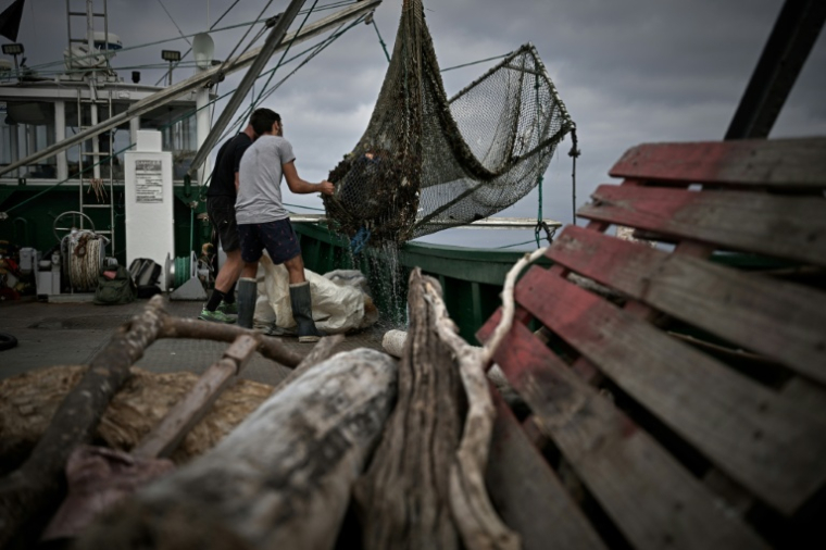 Des membres d'équipage de l'Itsas-Bellara vident un filet rempli de déchets à bord de leur bateau, le 8 septembre 2026 au large de Saint-Jean-de-Luz, dans les Pyrénées-Atlantiques ( AFP / Philippe LOPEZ )