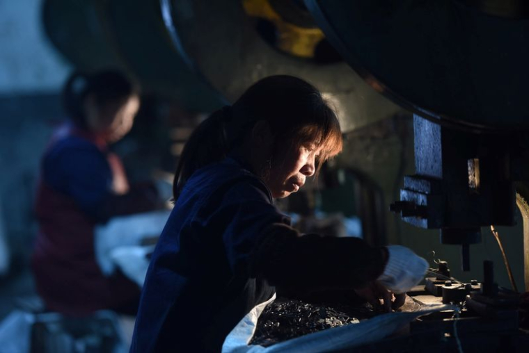 Des employés travaillent sur une chaîne de production fabriquant des pièces métalliques pour meubles dans une usine de Hangzhou