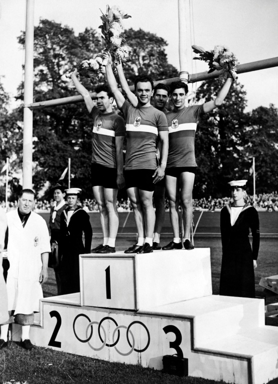 Charles Coste pose aux côtés de Pierre Adam, Serge Blusson et Fernand Decanali, sur la plus haute marche du podium des Jeux olympiques de Londres le 10 août 1948, après la victoire française à l'épreuve de poursuite par équipes ( AFP / - )