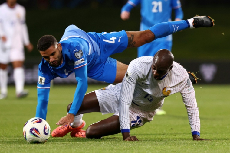 L'Islandais Victor Palsson (en bleu) et le Français Jean-Philippe Mateta sont à la luute en match de qualifications pour le Mondial-2026, le 13 octobre 2025 à Reykjavik ( AFP / FRANCK FIFE )