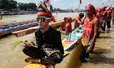 Rayyan Arkan Dikha assis à l'avant d'un bateau avant une course nautique traditionnelle, le 22 août 2025 sur la rivière Kuantan, dans la province indonésienne de Riau, sur l'île de Sumatra  ( AFP / Wahyudi )