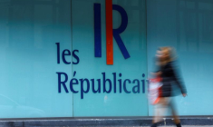 Une femme passe devant un logo du Parti français Les Républicains (LR) à Paris, France