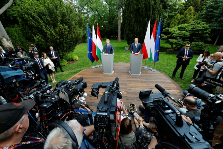 Le Premier ministre hongrois Peter Magyar (G) et son homologue polonais Donald Tusk donnent une conférence de presse à Varsovie le 20 mai 2026 ( AFP / Wojtek RADWANSKI )