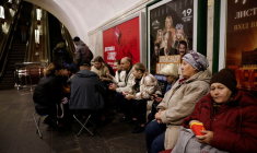 Des personnes s'assoient dans une station de métro pour s'abriter d'un raid aérien à Kiev.