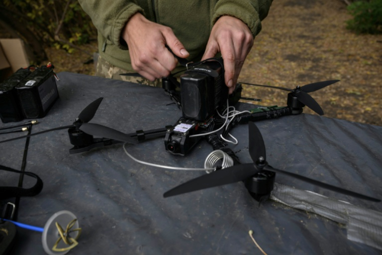 Un soldat ukrainien de l'unité "Black Wing" teste un drone FPV près de la ligne de front dans l'est de l'Ukraine, dans la région de Kharkiv, le 8 octobre 2025 ( AFP / Ed JONES )