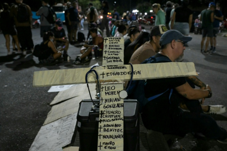 Une croix couverte des noms de personnes décédées est montrée lors d'une manifestation à Rosario, Argentine, le 11 février 2026 ( AFP / Juan MABROMATA )
