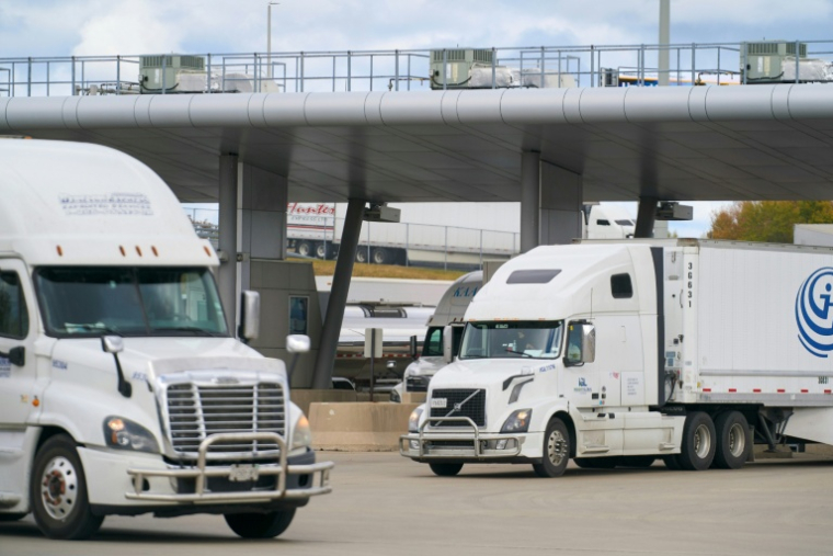 Des camions traversent le Canada en provenance des États-Unis au poste frontalier du pont Blue Water à Sarnia, en Ontario, le 24 octobre 2025 ( AFP / Geoff Robins )