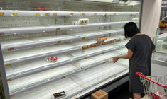 Une femme se tient devant un rayon de supermarché quasiment vidé à Hong Kong alors que le super typhon Ragasa approche de la ville, le 23 septembre 2025 ( AFP / Mladen ANTONOV )