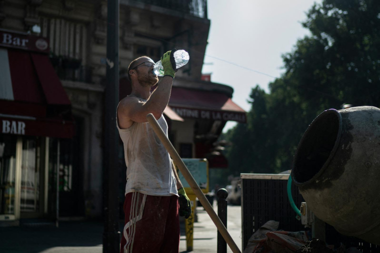 Un ouvrier boit de l'eau sur un chantier de construction à Paris, le 26 juin 2019, en pleine vague de chaleur.  ( AFP / KENZO TRIBOUILLARD )