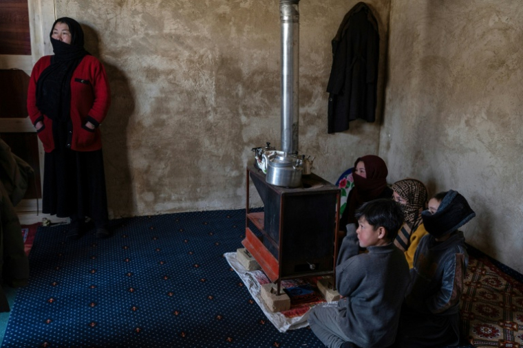 Arefa Ibrahimi (à gauche), une Afghane revenue d'Iran, répond devant ses enfants aux questions de l'AFP dans sa maison nouvellement construite à Jar-e-Khushk, dans la banlieue de la province de Bamiyan, le 19 janvier 2026 ( AFP / Wakil KOHSAR )