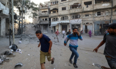 Des Palestiniens courent pour se mettre à l'abri après une frappe israélienne à Bureij, dans le centre de la bande de Gaza, le 19 octobre 2025  ( AFP / Eyad BABA )