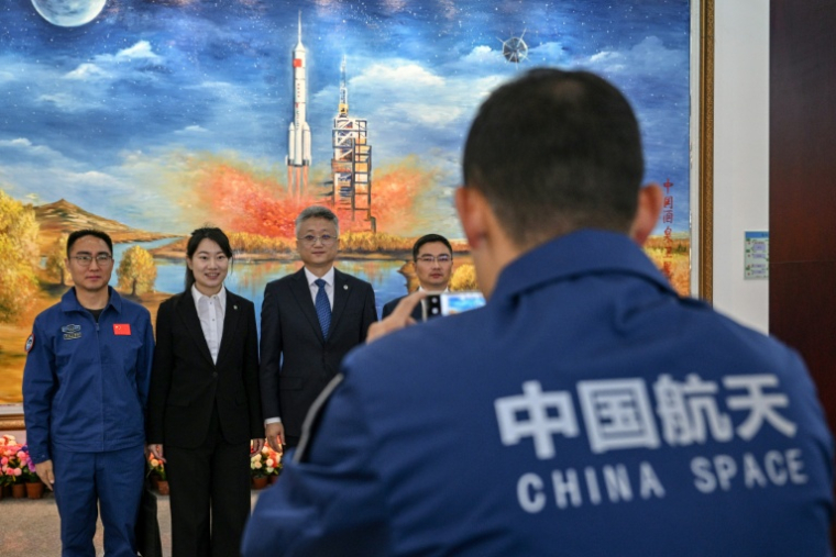 Zhang Jingbo (C), porte-parole du Programme spatial habité de la Chine, avec des membres du personnel après une conférence de presse sur la mission spatiale habitée Shenzhou-21, un jour avant le lancement de la mission au Centre de lancement de satellites de Jiuquan à Jiuquan, dans la province de Gansu, le 30 octobre 2025 ( AFP / Hector RETAMAL )