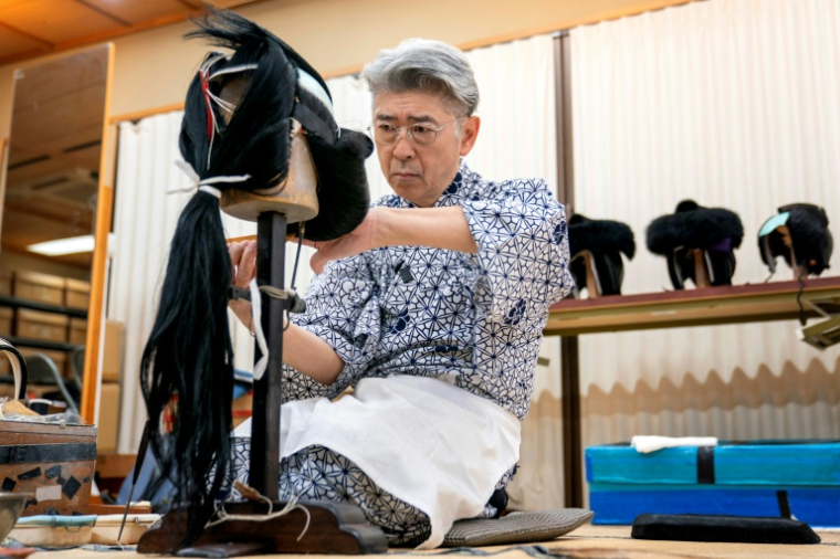 Le maître perruquier Tadashi Kamoji travaille sur une perruque pour les acteurs de kabuki dans son atelier à Tokyo, le 11 mars 2026 ( AFP / Kazuhiro NOGI )