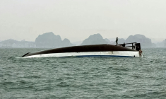 Un homme se tient sur un bateau touristique qui a chaviré dans la baie d'Halong, le 19 juillet 2025 ( AFP / - )