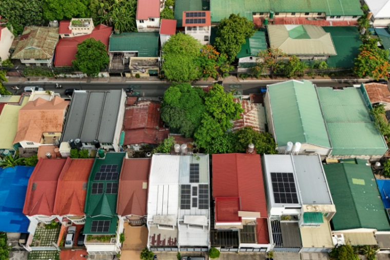 Vue aérienne montrant des panneaux solaires sur les toits de maisons dans un quartier résidentiel, le 7 juillet 2026 à Manille ( AFP / Jam STA ROSA )