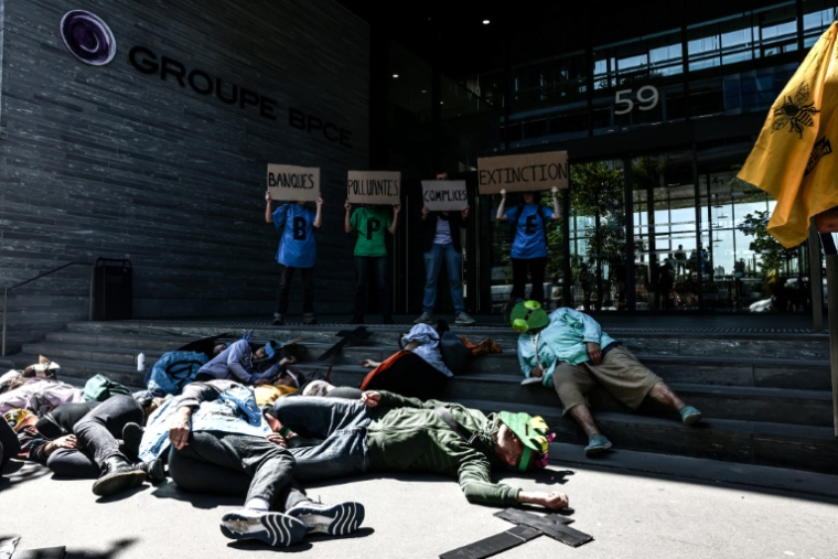 Des manifestants se rassemblent devant le siège du groupe bancaire BPCE avant l'assemblée générale de TotalEnergies, à Paris, le 16 mai 2025 ( AFP / Thibaud MORITZ )