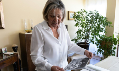 Claudine Spire regarde une photo de son enfance lors d'une interview à son domicile de Chaville,  en région parisienne, le 9 avril 2025 ( AFP / Xavier GALIANA )