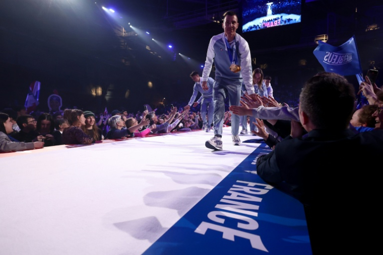 Quentin Fillon Maillet tape les mains des supporters en montant sur la scène, lors de la cérémonie pour fêter les athlètes français de retour des Jeux olympiques de Milan Cortina, le 23 février 2026 à Albertville ( AFP / Alex MARTIN )