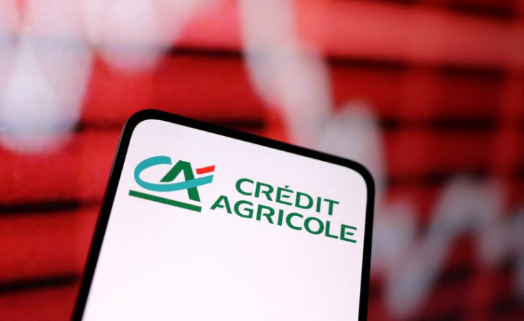 Une illustration du logo du Crédit Agricole et un graphique boursier en baisse