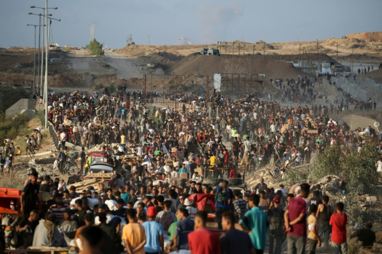 Des Palestiniens rassemblés à un point de distribution d'aide mis en place par la Fondation humanitaire de Gaza (GHF), près du camp de réfugiés de Nousseirat, dans le centre de la bande de Gaza, le 25 juin 2025 ( AFP / Eyad BABA )