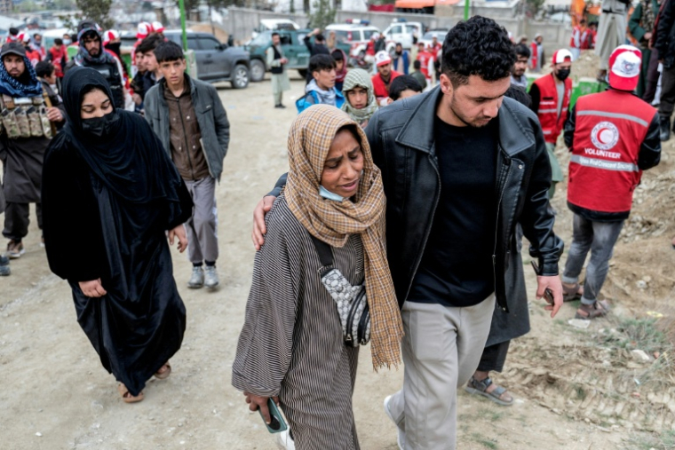 Samira Muhammadi se dirige vers la fosse commune lors de la deuxième cérémonie d’inhumation à Badam Bagh Hilltop, à Kaboul, le 26 mars 2026 ( AFP / Wakil KOHSAR )