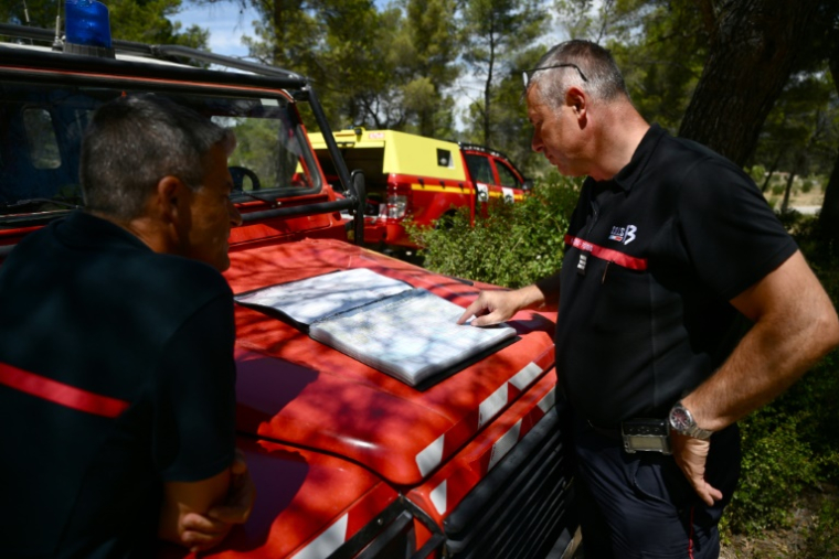 Des pompiers regardent une carte du département des Bouches-du-Rhône à Marseille, à Gardanne dans le sud de la France le 25 juillet 2023, alors que le département était en "alerte rouge", un risque élevé d'incendies de forêt. ( AFP / CHRISTOPHE SIMON )