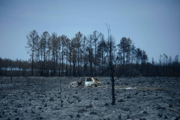Une voiture calcinée, touchée par l'incendie qui a ravagé la région de la Gironde, le 15 août 2026 dans la commune du Porge ( AFP / Olivier MORIN )