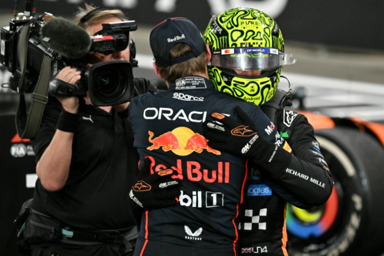 Lando Norris est félicité par Max Verstappen après avoir décroché son premier titre de champion du monde de Formule 1, le 7 décembre 2025 à Abou Dhabi ( AFP / Andrej ISAKOVIC )