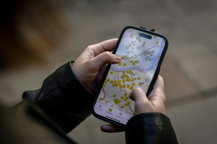 Ruta Gaskauskaite présente sur son téléphone une application qui permet aux utilisateurs de trouver les abris les plus proches, à Vilnius, le 28 mai 2026, en Lituanie ( AFP / Wojtek RADWANSKI )