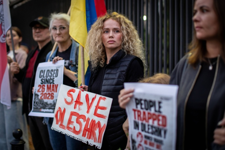 Des membres de la diaspora ukrainienne manifestent devant l'ambassade des États-Unis à Varsovie, le 6 octobre 2026, en Pologne pour réclamer un couloir humanitaire pour les habitants d'Olechky, une ville d'Ukraine assiégée par les Russes ( AFP / Wojtek RADWANSKI )