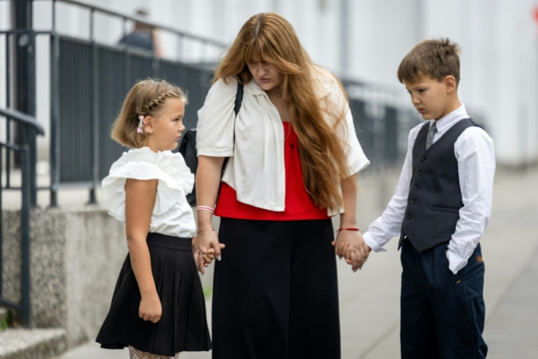 L'opposante bélarusse Antanina Kanavalava (c) accompagne sa fille Anastassia et son fils Ivan à l'école, le jour de la rentrée des classes, le 1er septembre 2025 à Varsovie, en Pologne ( AFP / Wojtek RADWANSKI )