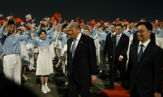 Le président américain Donald Trump (c) accompagné par le vice-président chinois Han Zheng (d) à son arrivée à l'aéroport international de Pékin, le 13 mai 2026 ( AFP / Brendan SMIALOWSKI )