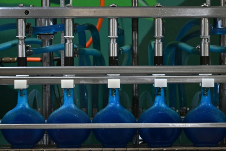 Des bouteilles de liqueur curaçao sur une ligne de production de la distillerie Willemstad, sur l'île néerlandaise de Curaçao, au large du Venezuela, le 9 avril 2026 ( AFP / Raul ARBOLEDA )