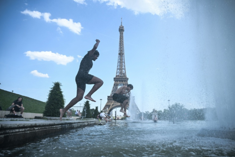 Des personnes sautent dans la fontaine du Trocadero, près de la tour Eiffel, à Paris le 22 juin 2026 ( AFP / JULIEN DE ROSA )