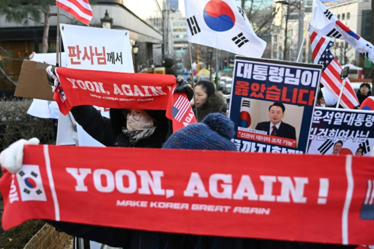Des partisans de l'ancien président sud-coréen destitué, Yoon Suk Yeol, rassemblés devant le tribunal du district central de Séoul où doit se tenir son dernier procès pénal pour insurrection, le 13 janvier 2026 ( AFP / Jung Yeon-je )
