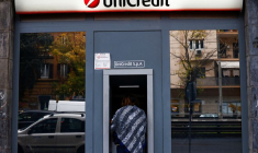 Une personne utilise un distributeur automatique de billets dans une agence bancaire UniCredit à Rome