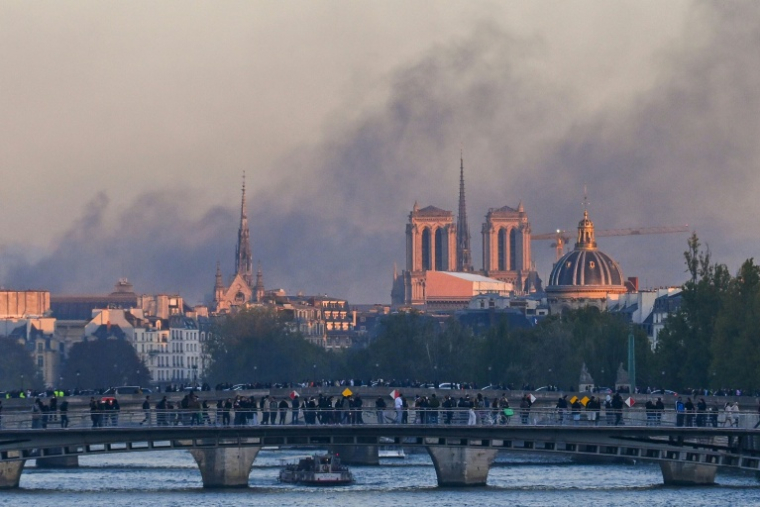 De la fumée s'élève de Paris le jour des manifestations "contre la vie chère", avec la cathédrale Notre-Dame en arrière-plan, le 17 octobre 2026 ( AFP / Guillaume Saligot )