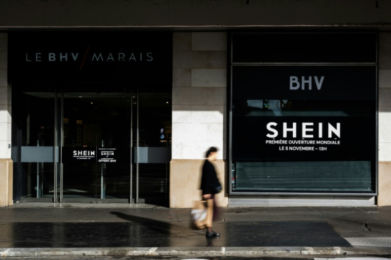 Une des entrées du Bazar de l'Hotel de Ville (BHV) à Paris, le 3 novembre 2025, avec une affiche annonçant l'ouverture d'un espace Shein pour le 5 novembre    ( AFP / Julie SEBADELHA )