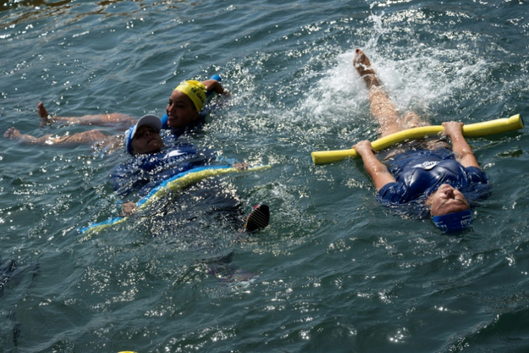 Des mères des quartiers Nord de Marseille participent à un cours de natation dispensé par l'association "Le Grand Bleu" dans une piscine d'eau de mer près du port de l'Estaque, le 11 août 2025 ( AFP / Miguel MEDINA )