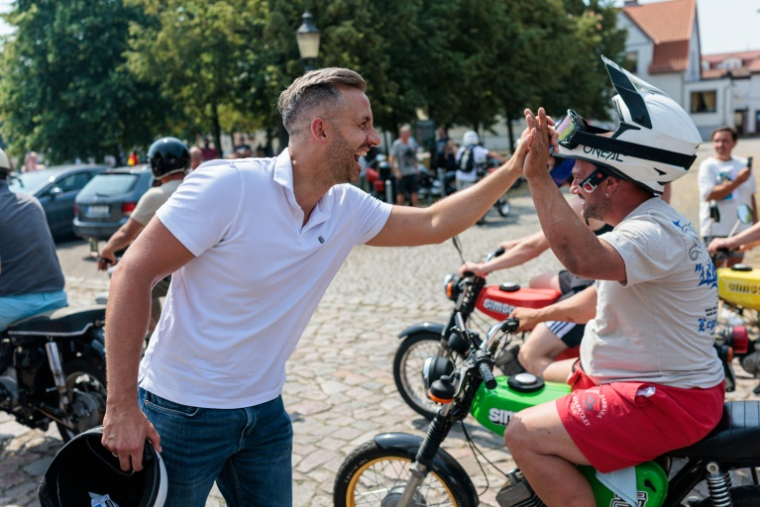 Ulrich Siegmund (g), tête de liste de l'AfD pour les élections régionales en Saxe-Anhalt, salue un sympathisant lors d'un événement de campagne et un rassemblement de motos et de cyclomoteurs à Jessnitz, dans l'est de l'Allemagne, le 28 juin 2026 ( AFP / Jens SCHLÜTER )