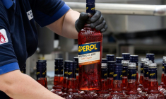 Un ouvrier de l'usine phare du groupe Campari à Novi Ligure, dans le nord-ouest de l'Italie, tient une bouteille d'Aperol, le 21 juillet 2026 ( AFP / Marco Bertorello )