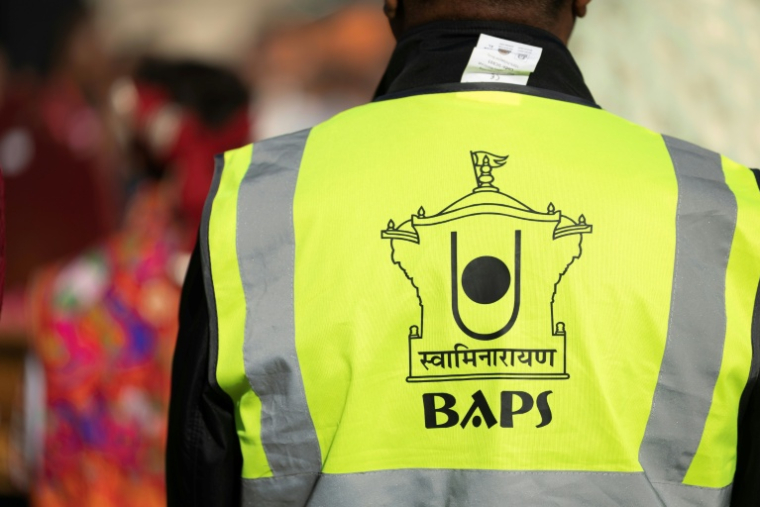 Un participant à la célébration du premier temple BAPS en France porte un gilet jaune au logo de la communauté, le 3 septembre 2026, à Paris ( AFP / Kenzo TRIBOUILLARD )