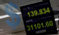 Un logo du dollar américain et la valeur du Yen à la société d'échange de devises Gaitame.com à Tokyo