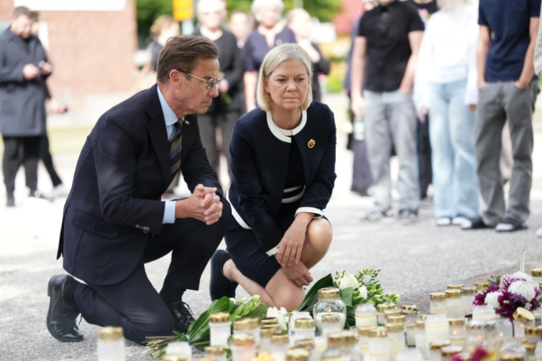 Le Premier ministre suédois Ulf Kristersson (G) et la cheffe du Parti social-démocrate Magdalena Andersson devant le lycée où une attaque à l'épée a coûté la vie à une élève de 17 ans, le 22 août 2026 à Fagersta, dans le centre de la Suède ( TT NEWS AGENCY / Magnus LEJHALL )