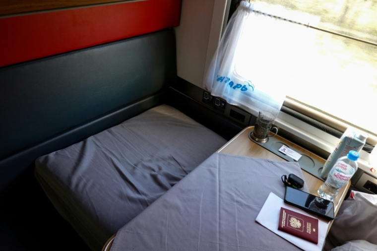Un passeport russe posé sur une table dans une voiture du "Yantar", le train qui relie Moscou à l'enclave russe de Kaliningrad, le 14 octobre 2025 ( AFP / STRINGER )