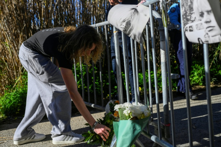 Une femme dépose un bouquet de fleurs en hommage à Brigitte Bardot à l'entrée de la propriété de la star décédée à Saint-Tropez, le 28 décembre 2025 ( AFP / Frederic DIDES )